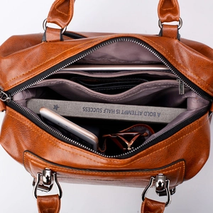 Brown crocodile embossed leather Boston bag showing spacious interior with zipper pockets