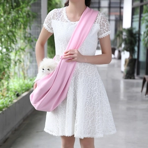 Close-up of a pink soft fabric pet sling carrier bag with a small white dog inside