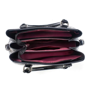 Macro view of black leather tote with burgundy lining and multi-compartment interior