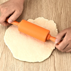 30.5cm large orange non-stick silicone rolling pin used on dough on wooden tabletop