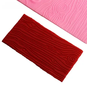 Close-up of flexible silicone mold featuring realistic wood grain texture for cake decorating