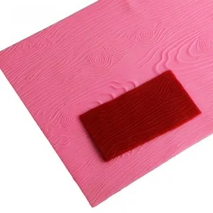 Detailed view of pink and red silicone molds with realistic wood bark texture for baking