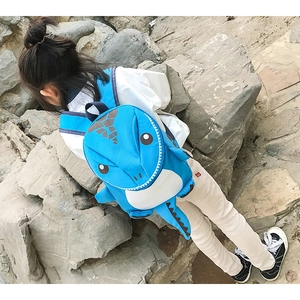 Close-up of 3D cartoon dinosaur backpack with soft spikes and blue fabric texture