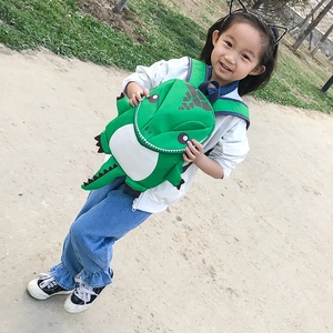 Detailed view of kids cartoon dinosaur backpack in bright green with 3D spine scales