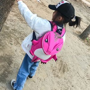Detail of pink 3D dinosaur backpack for toddlers showing dorsal fins and blue straps