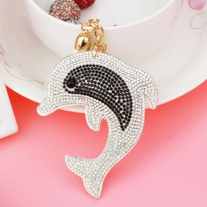Detailed close-up of a rhinestone dolphin keychain with gold bell and lobster clasp