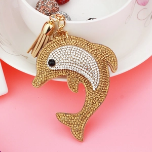 Detailed view of dolphin keychain with gold and white rhinestones and brown tassel