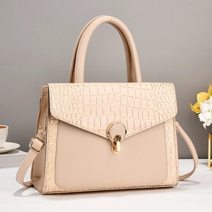Detail of apricot tote bag with crocodile pattern leather and gold metal buckle