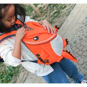 Detailed view of kids orange dinosaur backpack with 3D fins and adjustable straps
