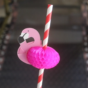 Detail shot of red striped paper straw with a pink flamingo honeycomb decorative ornament