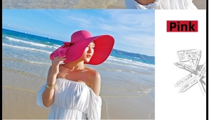 Detalle de sombrero de paja de ala ancha rojo rosa con lazo de cinta en la playa