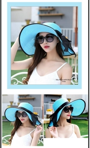 Sombrero de sol plegable azul cielo de ala ancha con ribete negro y detalle de lazo