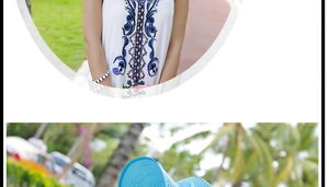 Detalle de sombrero de paja azul y vestido boho blanco con bordado floral marino