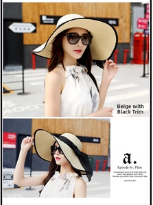 Detalle de sombrero de paja beige de ala ancha con lazo negro para playa y sol