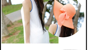 Detalle de sombrero de paja naranja de ala ancha con un gran lazo decorativo elegante