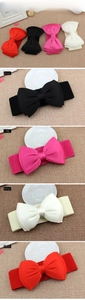 Close-up of four colors of women's elastic bow belts with silk satin fabric texture