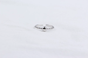 Detailed view of adjustable 925 silver beaded ring with central ball on white fabric