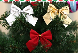 Vue détaillée de nœuds dorés, argentés et rouges disposés sur un sapin de Noël