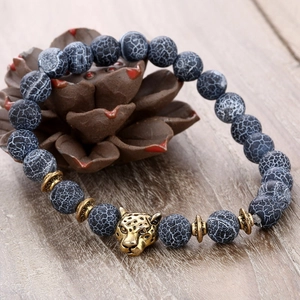 8mm black weathered agate bead bracelet with antique gold leopard head on wood surface
