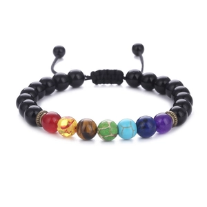 Macro detail of adjustable woven 7 chakra bead bracelet with natural tiger eye stones