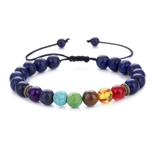 Detailed macro view of seven chakra stone beads on an adjustable braided cord bracelet