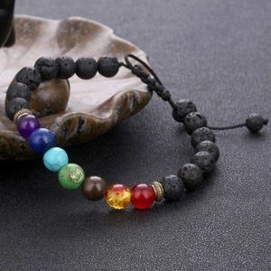 Macro detail of adjustable seven chakra lava stone beaded yoga bracelet with woven cord