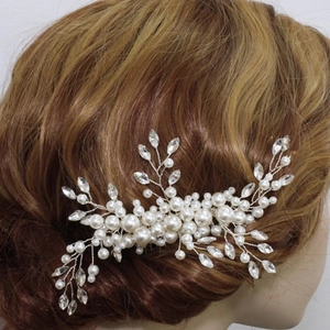 Detail of silver bridal hair comb with handmade pearls and leaf rhinestones in hair