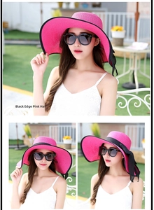 Detalle de sombrero de paja rosa fucsia con lazo negro y ala ancha para playa