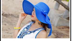 Detalle de sombrero de paja azul con lazo grande para protección solar en las vacaciones