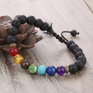 Detail of adjustable chakra lava stone bracelet on decorative ceramic lotus base
