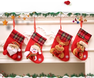 Detail of four Christmas stockings featuring Santa, snowman, reindeer, and bear with plaid cuffs
