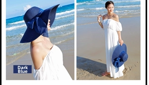 Detalle de sombrero de paja azul marino de ala ancha con lazo para vacaciones de playa