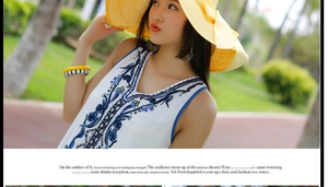 Detalle de bordado floral azul y lentejuelas en vestido de playa blanco con cuello V