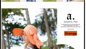 Detalle de un sombrero de paja naranja plegable con lazo grande y fondo de palmeras