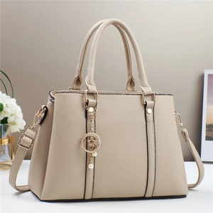 Close-up of beige leather handbag texture with gold star and moon pearl pendant decoration