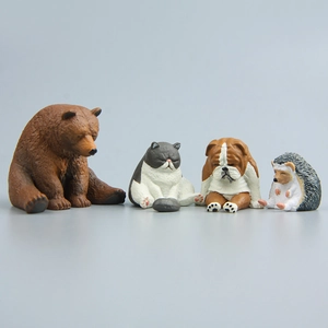 Detailed view of four sleepy resin animal figurines: bear, cat, bulldog, and hedgehog