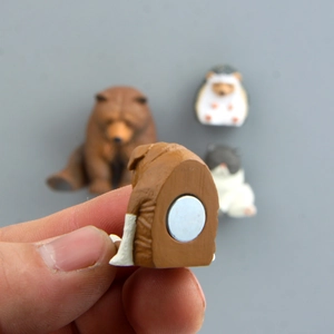 Close-up of a resin animal fridge magnet showing the strong circular magnet on back