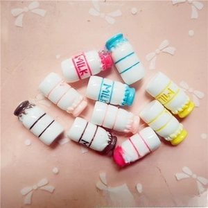 Detailed close-up of mini resin milk bottle charms with MILK text for DIY crafts