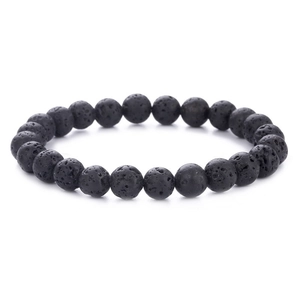 Detailed close-up of natural black lava stone beaded bracelet on white background