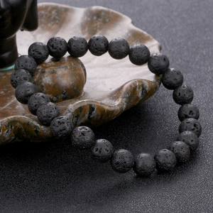 Handcrafted black lava stone beaded bracelet on decorative ceramic display tray