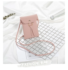 Dettaglio di una mini borsa a tracolla rosa per cellulare su un fondo estetico bianco.