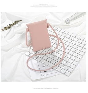 Elegante mini borsa a tracolla rosa per cellulare in ecopelle su sfondo bianco minimalista