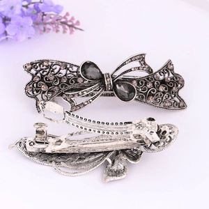 Detail of vintage silver bow hair clip with grey crystals and metal spring clamp
