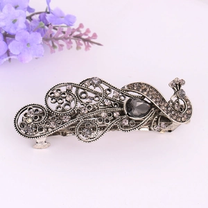 Macro view of vintage peacock hair clip with gray crystals and antique silver finish