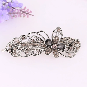 Macro detail of vintage silver alloy hair clip with smoky crystal and floral patterns