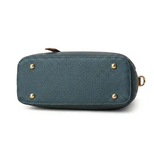 Dettaglio della base della borsa in pelle blu testurizzata con quattro piedini d'oro