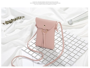 Elegante mini borsa a tracolla rosa per cellulare con nappa dorata in un ambiente minimalista