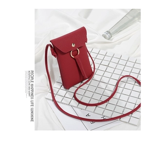 Dettaglio di mini borsa per telefono in pelle martellata rossa con fibbia ad anello d'oro