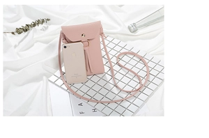 Mini borsa a tracolla rosa con dettaglio nappa mostrata con smartphone per confronto taglie