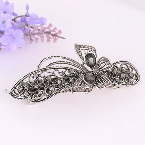 Detailed macro view of retro butterfly hair clip with grey crystals and silver alloy